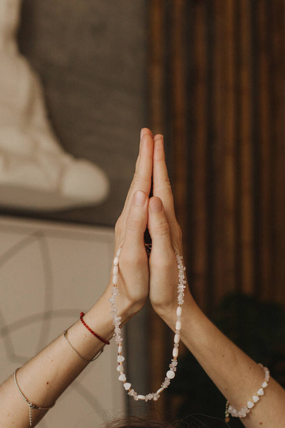 Frau hält Schmuck aus Natursteinen in der Hand, ihre Hände sind mit Ringen und Armbändern verziert. Kunsthandwerk und Kreativität. Spiritualität, Religion, Gotteskonzept. - Foto, Bild