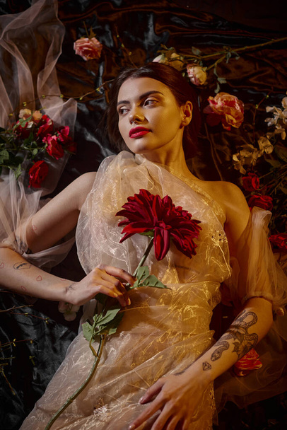 feminine elegance, charming woman in romantic transparent dress lying among beautiful flowers - Foto, Imagem