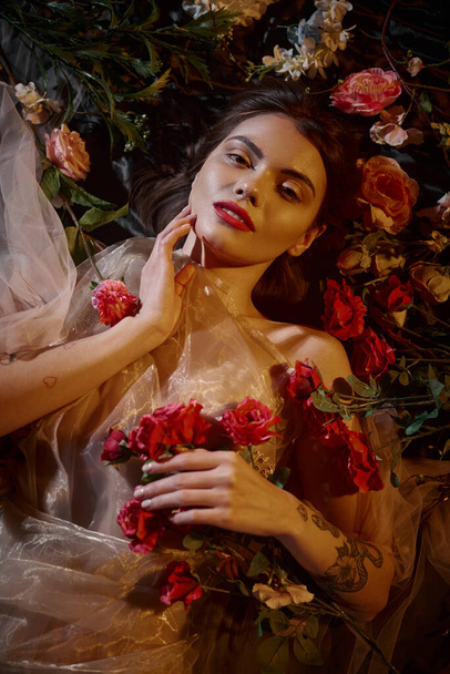 美しい花の間に横たわり,カメラを見ているロマンチックな透明なドレスの官能的な女性 - 写真・画像