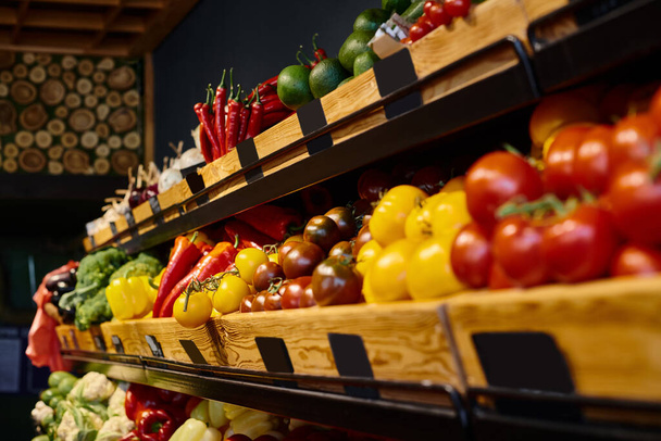 object photo of colorful vegetable stall with tomatoes and peppers at grocery store, nobody - Photo, Image