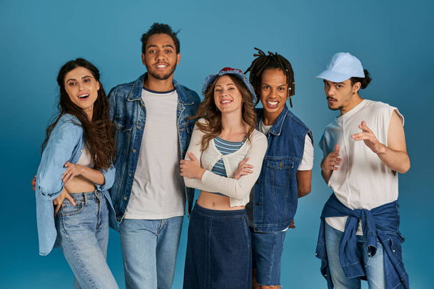 Gruppenporträt multikultureller Freunde in modischer Freizeitkleidung, die auf blauem Grund in die Kamera schauen - Foto, Bild