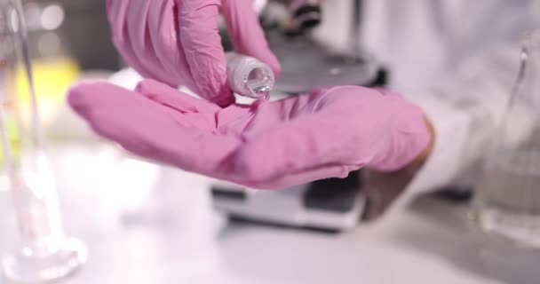 Επιστήμονας χημικός σε προστατευτικά γάντια ρίχνει υγρό μέταλλο στο χέρι σε εργαστήριο closeup 4k ταινία αργή κίνηση. Έννοια τοξικών χημικών στοιχείων Hg - Πλάνα, βίντεο