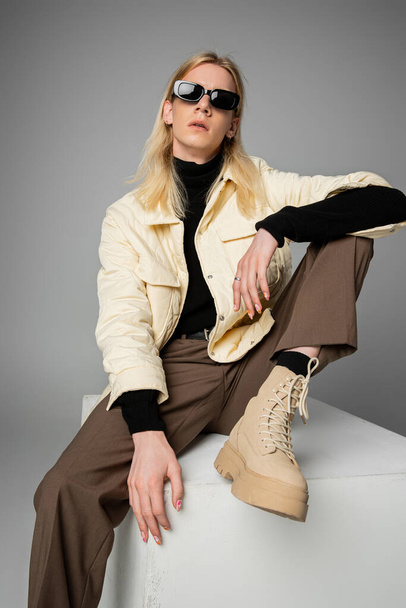 κάθετη λήψη του κομψού ανδρόγυνου προσώπου σε χειμερινό σακάκι και μοντέρνα γυαλιά ηλίου, έννοια της μόδας - Φωτογραφία, εικόνα