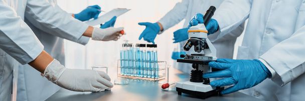 Skupina specializovaných vědců provádí chemický experiment s použitím mikroskopu v lékařské laboratoři k vývoji nové vakcíny nebo antibiotika. Koncept biotechnologické laboratoře a lékařského výzkumu. Neoterický - Fotografie, Obrázek