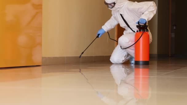 Specialist in protective suit and mask disinfects premises. Services of disinfection of premises from microorganisms concept - Footage, Video