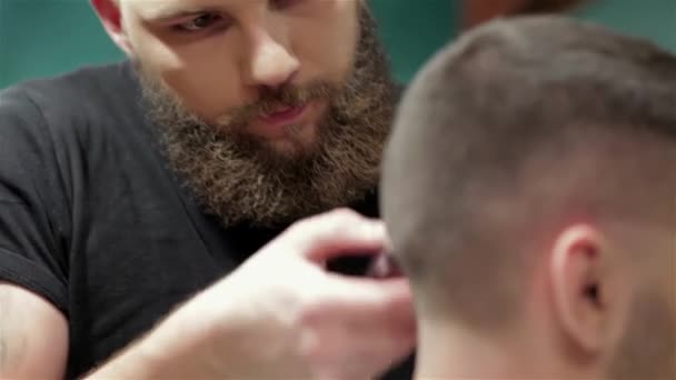Penteado masculino e corte de cabelo em uma barbearia ou salão de cabeleireiro. A arrumar a barba. Barbearia. Homem cabeleireiro fazendo barba de corte de cabelo homens adultos no salão de cabeleireiro dos homens. Cabeleireiros no local de trabalho
 - Filmagem, Vídeo