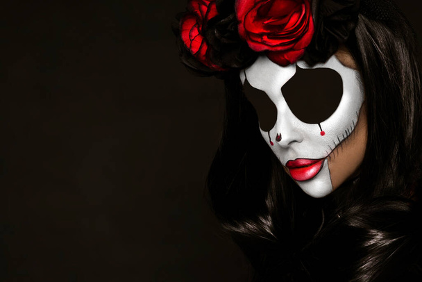 Portrait d'une femme avec un maquillage de crâne sexy sur fond noir. Costume et maquillage d'Halloween. Portrait de Calavera Catrina - Photo, image