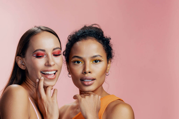 Mieszane kobieta zdrowe kolorowe piękno różowy połysk afrykańska pielęgnacja ciała portret twarz dziewczyny atrakcyjne oko makijaż skóra dwa studio razem szczęśliwy piękny amerykański wyścig model - Zdjęcie, obraz
