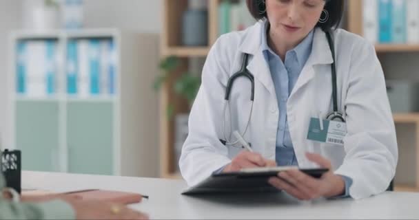 Heathcare, writing and woman consulting doctor in consultation room for insurance, checklist or paperwork. Hospital, clipboard and female patient with gp in a clinic for advice, history or plan. - Footage, Video
