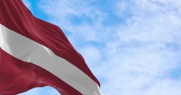 Bandera nacional de la República de Letonia ondeando al viento en un día despejado. Campo rojo con una línea horizontal blanca en el centro. Animación de renderizado 3d sin costuras. Circuito de cámara lenta. Enfoque selectivo. 4k - Metraje, vídeo