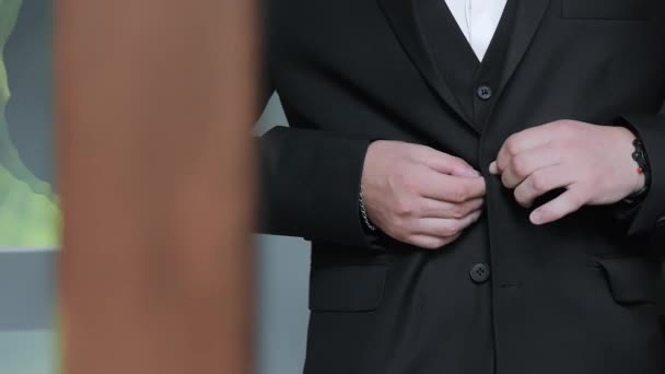 Mens hands fasten buttons on a suit jacket. Close up. - Footage, Video