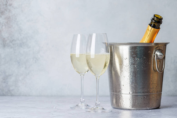 Dois copos de champanhe e garrafa em balde de gelo com espaço de cópia - Foto, Imagem