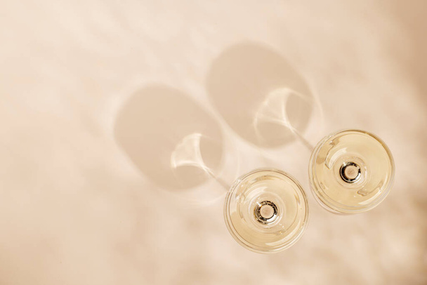 Два бокала шампанского на бежевом фоне с копировальным пространством - Фото, изображение
