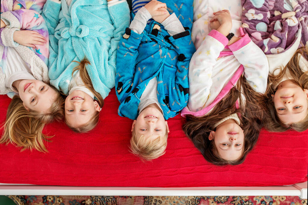 Feliz Navidad y Felices Fiestas. Grupo de niños divirtiéndose en la fiesta de pijama. Acogedora casa - Foto, imagen