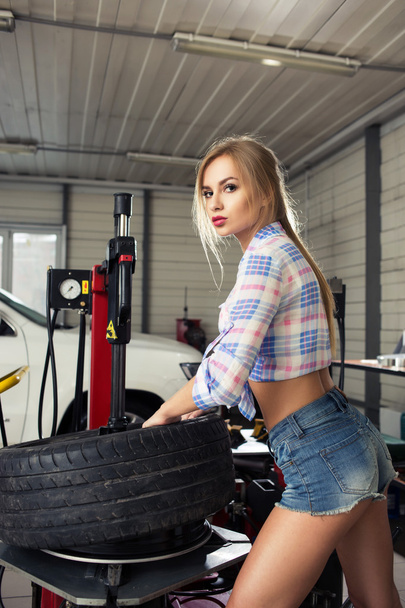 girl mechanic replace tires on wheels - Φωτογραφία, εικόνα