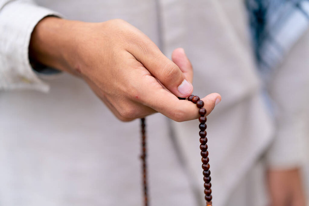 イスラム教の男性の手は,改宗とアッラーの崇拝の祈りの間にローズマリーを保持しています. - 写真・画像