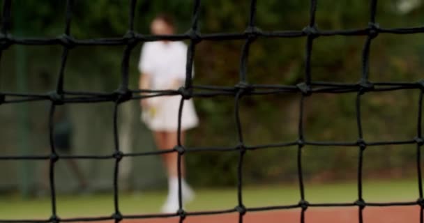 Σαββατοκύριακο και Κυριακή δραστηριότητα για αναψυχή. Γυναίκα παίζει τένις στο γήπεδο ταπήτων έξω. Αθλητισμός ενεργό παιχνίδι με τους φίλους. Παίκτης του τένις εν δράσει. Αγώνας τένις. Ενεργό παιχνίδι αναψυχής. - Πλάνα, βίντεο