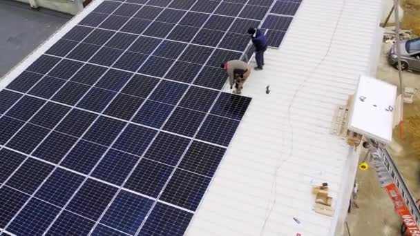 A modern napelemek tiszta elektromosságot termelnek. Napelemes technikus napelemeket telepít a ház tetejére. Megújuló energia, technológia, villamos energia, szolgáltatás, zöld, jövő. erőmű.  - Felvétel, videó