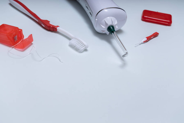 A szájhigiénia alapvető eszközeit tartalmazó átfogó fogápolási készlet. A készlet tartalmaz egy öntözőkészüléket, egy fogkefét és fogselymet. Fénymásolási hely. - Fotó, kép