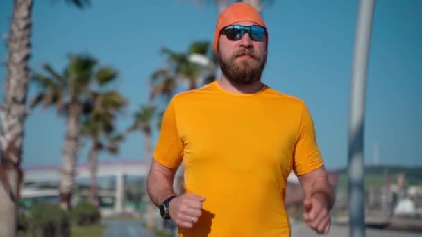 Hombre de mediana edad hace correr ejercicio de jogging maratón de preparación de la mañana soleado. Estilo de vida saludable para adultos de mediana edad, perder peso, quemar grasa, entrenamiento físico - Imágenes, Vídeo
