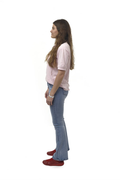 πλαϊνή όψη ενός νεαρού κοριτσιού που στέκεται σε λευκό φόντο - Φωτογραφία, εικόνα