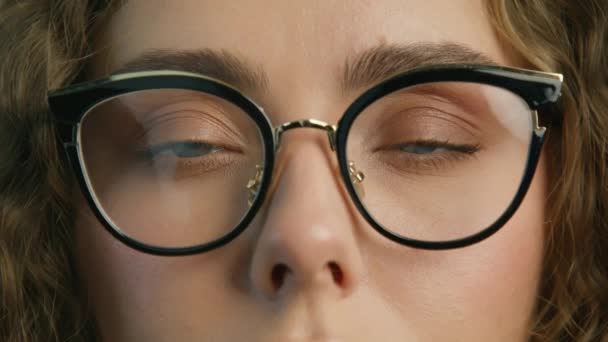 Smart people healthy vision concept. Beautiful woman with blue eyes 4K. Close up view of focused businesswoman wears stylish computer glasses for reducing eye strain blurred vision looking at camera - Кадры, видео
