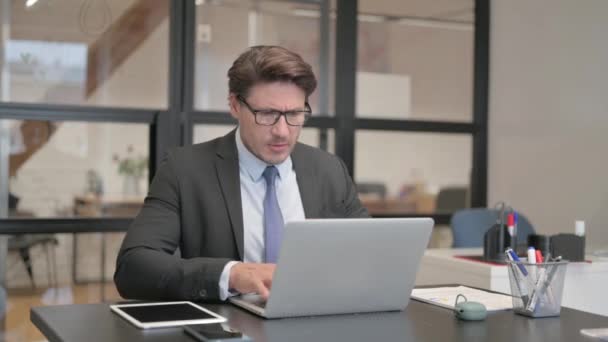 Επιχειρηματίας που έχει πονοκέφαλο, ενώ εργάζονται σε φορητό υπολογιστή στο γραφείο - Πλάνα, βίντεο