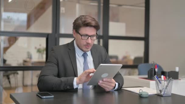 Joven empresaria celebrando en la tableta mientras está sentada en un banco - Imágenes, Vídeo