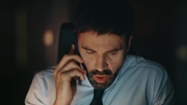 Concerned manager arguing at telephone call sitting office late evening close up. Frustrated nervous businessman finish phone conversation at workplace. Stressed ceo dissatisfied by communication. - Footage, Video