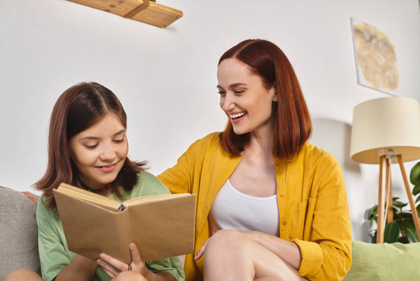 veselý preteen dívka čtení speciální sexuální výchova literatura poblíž matka doma v obývacím pokoji - Fotografie, Obrázek