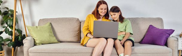 mujer feliz con hija adolescente viendo la película en el ordenador portátil en el sofá en la sala de estar, pancarta - Foto, Imagen