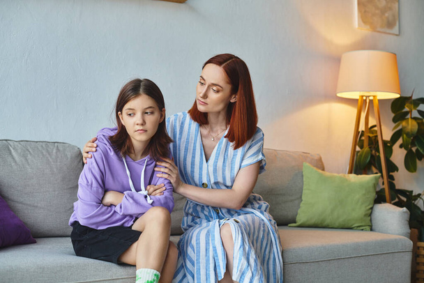 gondoskodó anya nyugtató ideges tizenéves lánya ül a kanapén a nappaliban, gondozás és támogatás - Fotó, kép