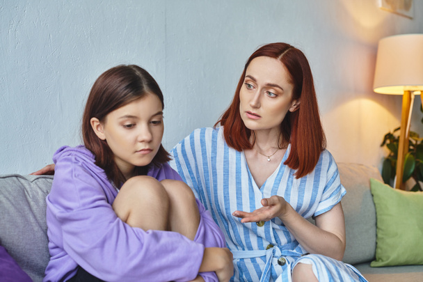 caring mother talking to frustrated teenage daughter sitting on couch at home, love and support - Fotó, kép