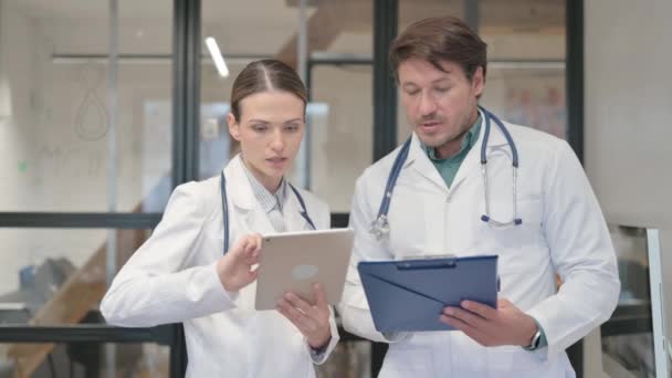 医師とデジタルタブレットに関する医学レポートを議論する女性医師 - 映像、動画