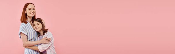 щаслива жінка з дочкою-підлітком у стильному повсякденному вбранні, дивлячись на камеру на рожевому тлі, банер - Фото, зображення
