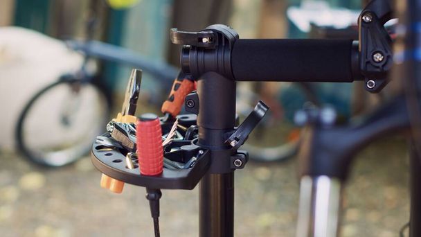 詳細なショットは,自転車のメンテナンス作業のために準備された修理スタンドに細心の注意を払って編成された専門機器の品揃えをキャプチャします. 自転車修理のためのレンチドライバーやその他のツールの表示. - 写真・画像