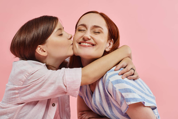 adolescente abrazando y besando feliz madre sonriendo con los ojos cerrados en rosa, el amor y la unidad - Foto, Imagen
