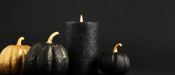 Painted pumpkins and candle on dark background with space for text. Halloween celebration - Photo, Image