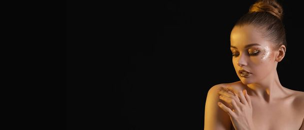 Mladá žena se zlatými třpytkami make-up na černém pozadí s prostorem pro text - Fotografie, Obrázek