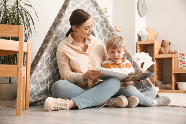 Kindermädchen liest kleinen Jungen zu Hause Märchen vor - Foto, Bild