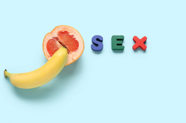 Word seks en snijd grapefruit met banaan op blauwe achtergrond - Foto, afbeelding