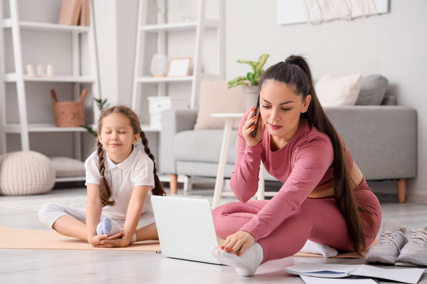 Working mother with her little daughter training at home - Photo, Image