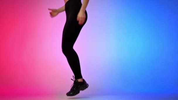 Молодая улыбающаяся женщина в спортивном костюме в виртуальной реальности VR гарнитура бег в студии с синим и красным фоном - Кадры, видео
