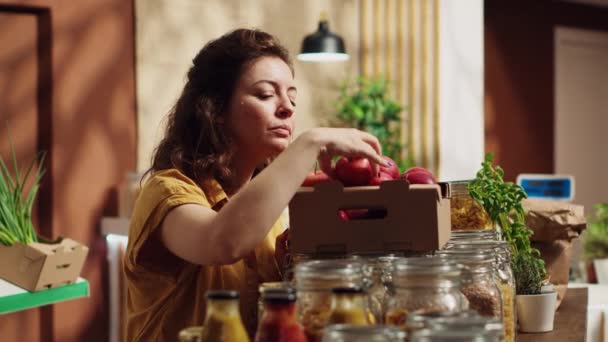 Mujer vegana en eco amigable cero desperdicio supermercado contando manzanas, agregándolas a la cesta de la compra. Cliente en la tienda de comestibles de barrio local recogiendo frutas cultivadas a mano - Imágenes, Vídeo