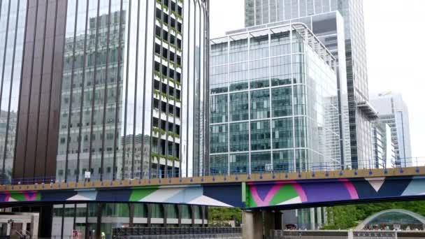 LONDRES, REINO UNIDO - 12 DE SEPTIEMBRE DE 2023: Paisaje urbano del distrito de Canary Wharf, canales de agua con puente, edificios modernos y rascacielos alrededor - Imágenes, Vídeo