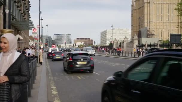 LONDRES, REINO UNIDO - 11 de agosto de 2023: Paisaje callejero del centro de la ciudad con múltiples personas caminando y coches en movimiento cerca del Palacio de Westminster - Metraje, vídeo