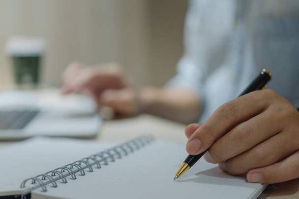 férfi kéz tollal írás jegyzetfüzetbe az irodában.tanulás, oktatás és a work.writes célokat, terveket, hogy nem, és kívánságlistát az asztalon. - Fotó, kép