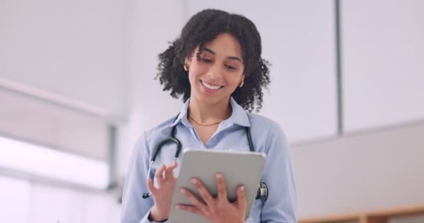 Tablet, smile and woman doctor doing research in hospital for medical diagnosis or treatment. Happy, digital technology and female healthcare worker scroll on the internet for information in a clinic. - Footage, Video