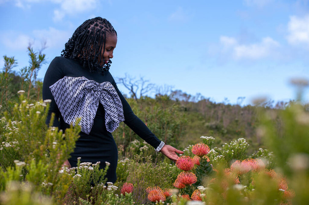 Donna visto toccare fiore in natura - Foto, immagini