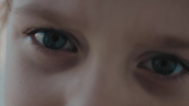 Κοντινό πλάνο του μικρού κοριτσιού με μπλε μάτια με αυθάδη, τρελή, αναστατωμένη έκφραση - Πλάνα, βίντεο